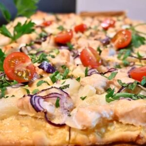 Ein köstlicher Flammkuchen mit Lachs, Spargel und würzigem Sriracha-Schmand. Dekoriert mit frischer Petersilie und Kirschtomaten.