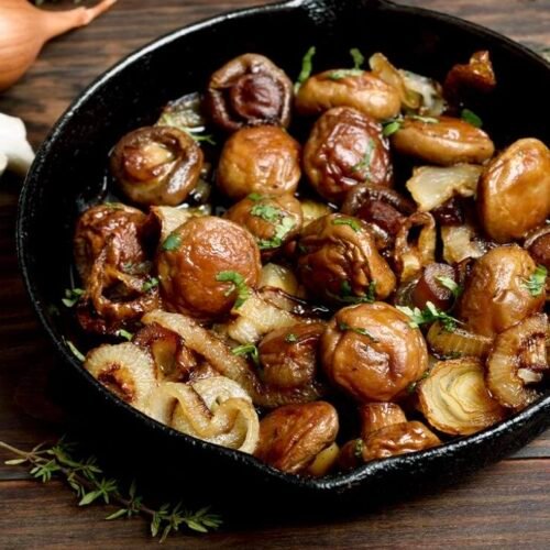 Bunte Champignon-Gemüsepfanne mit Zucchini, Porree und Tofu in einer Pfanne serviert.